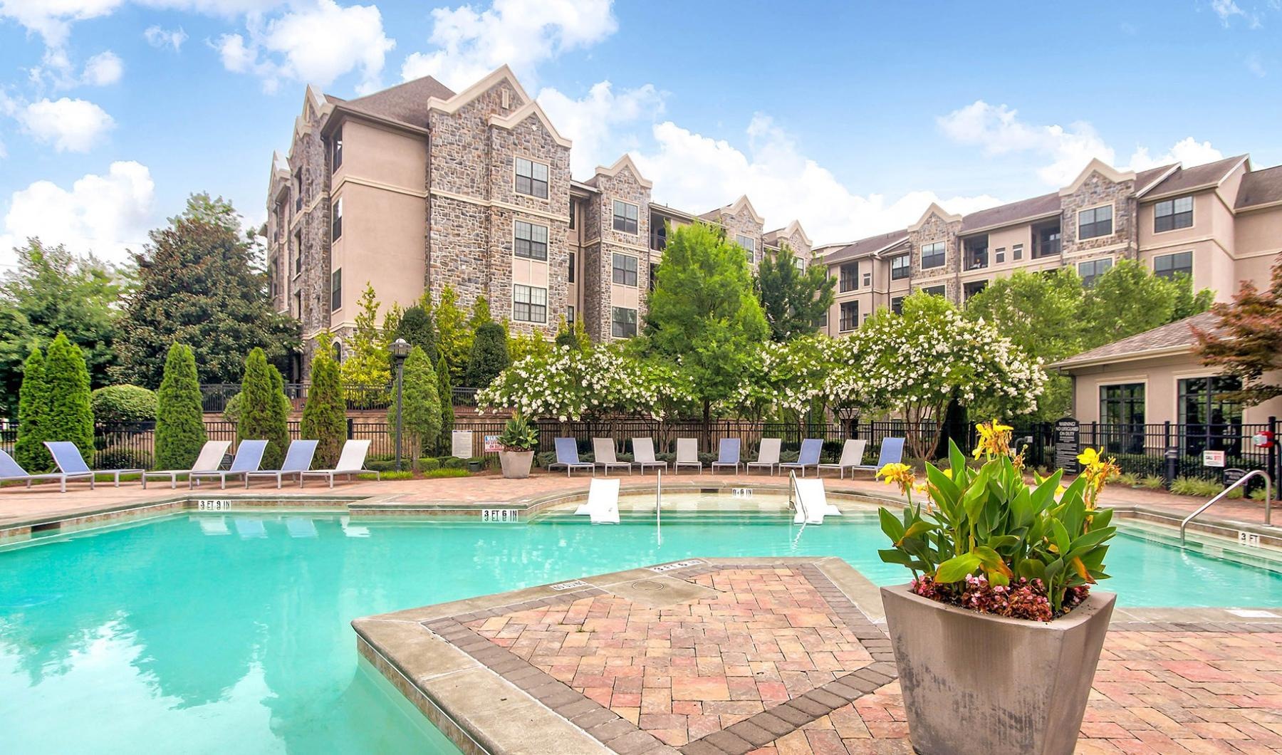 a swimming pool with lush landscaping